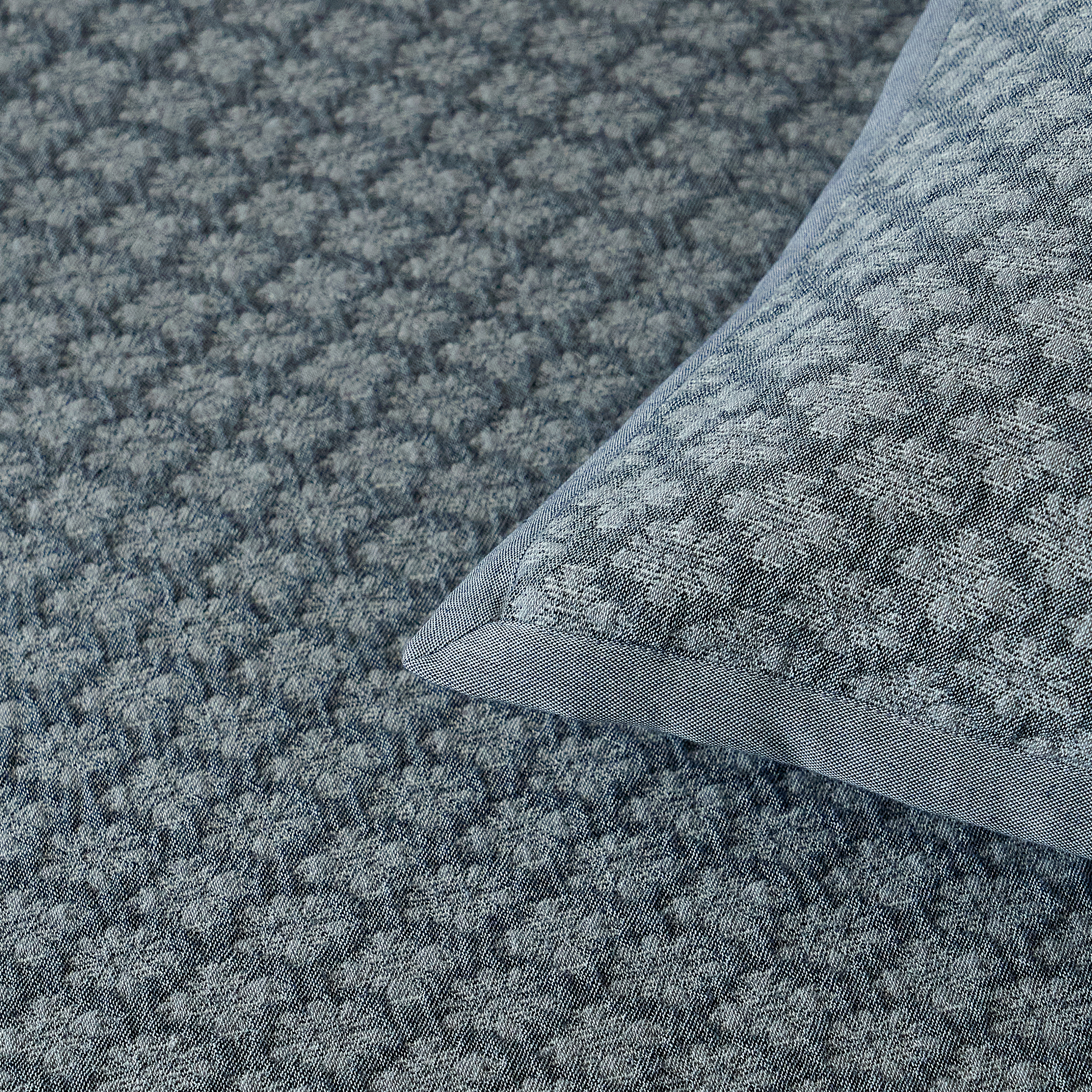 Close-up of the tailored corner detailing on the slate blue diamond jacquard pillow sham.