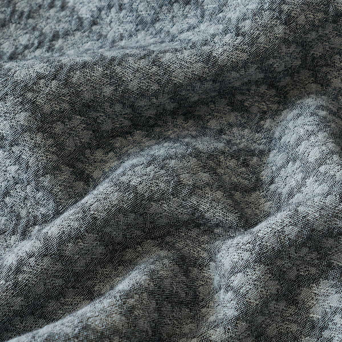 Close-up of soft slate blue washed cotton fabric with natural texture and subtle variations