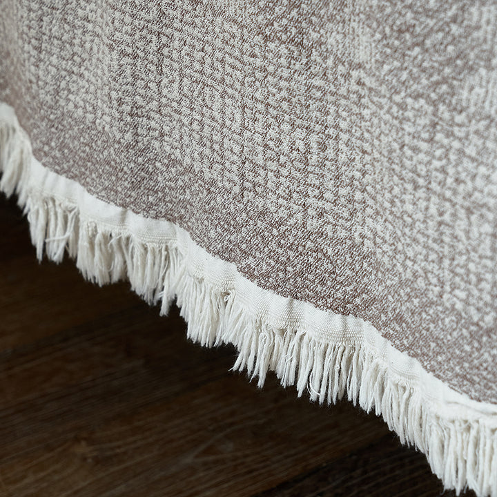 Close-up of the delicate fringe edge on the taupe brown jacquard woven striped throw.