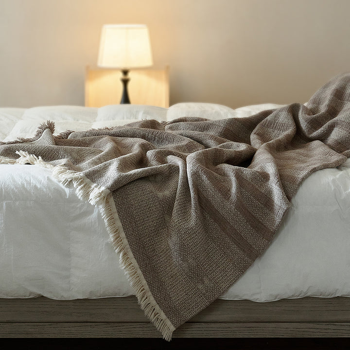 Large taupe brown striped cotton-linen throw used as a summer bedspread on a white bed.