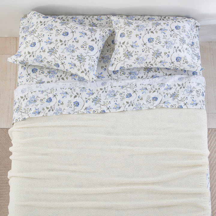 Top-down bird's-eye view of a neatly made bed featuring the DAUAOTO Provence blue floral sheet set layered with a white blanket.