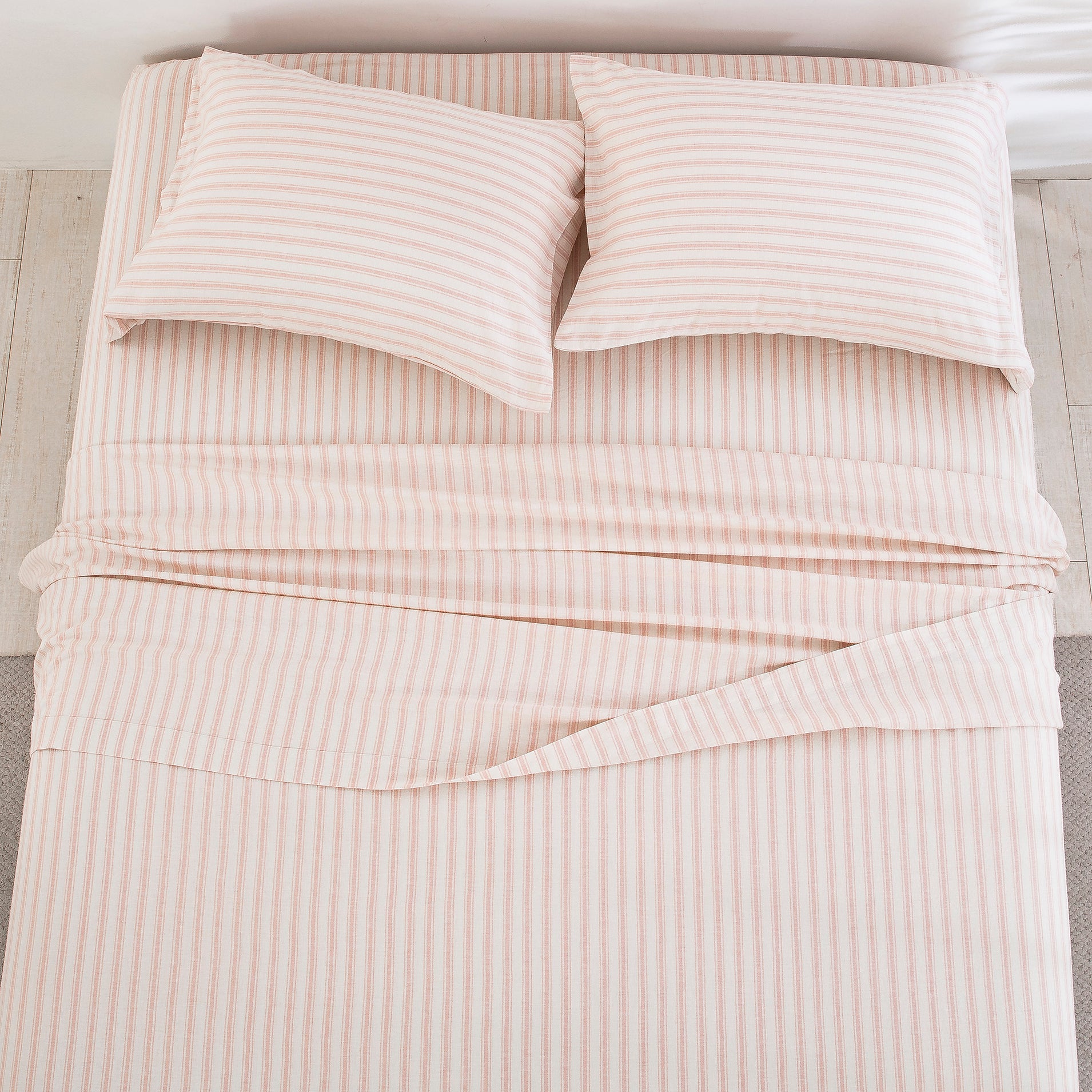 Top-down view of the airy elegance and finely tailored blush pink stripe pattern of the linen cotton bed sheets - DAUAOTO