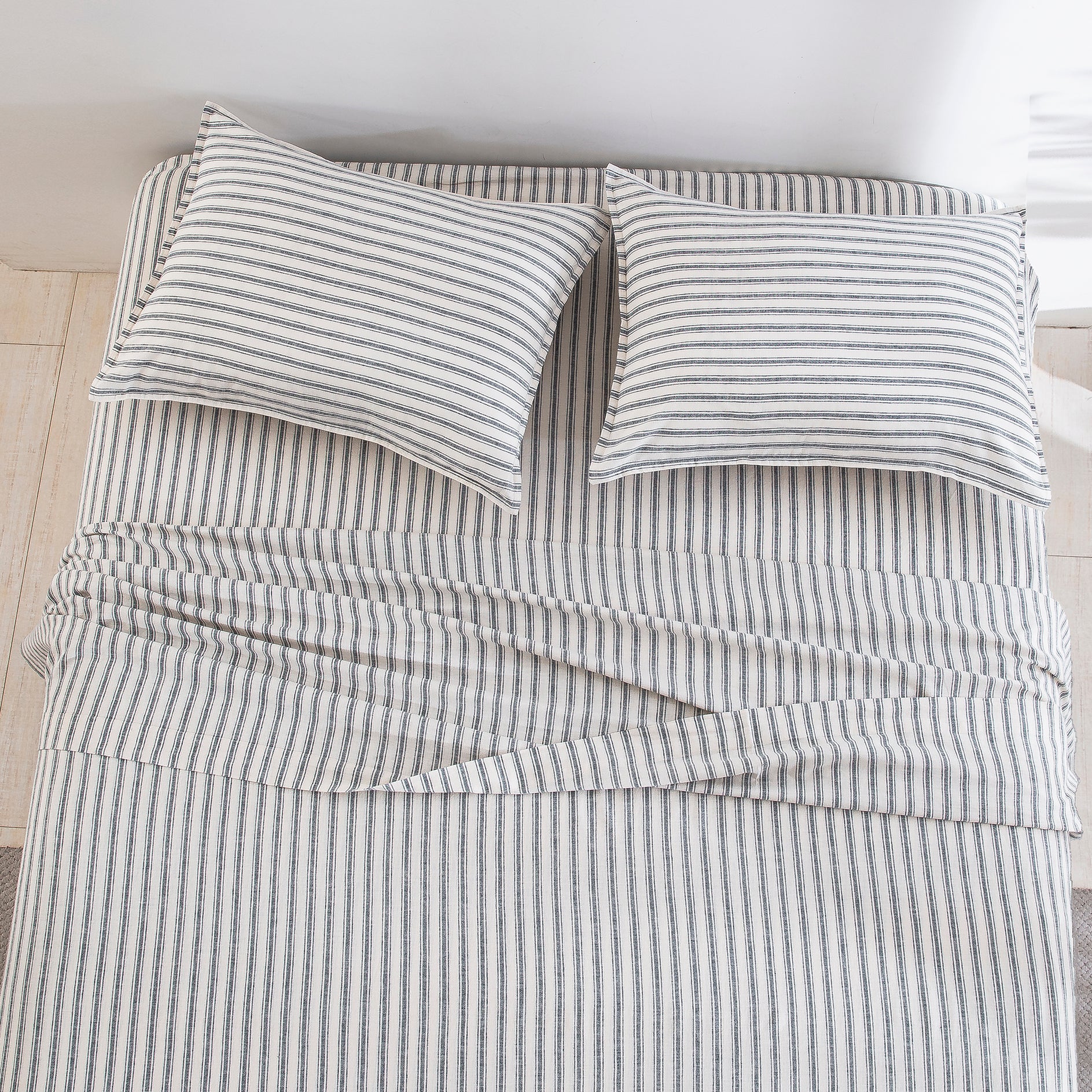 Top-down view of the tailored elegance and classic grey ticking stripe pattern of the linen cotton bed sheets - DAUAOTO