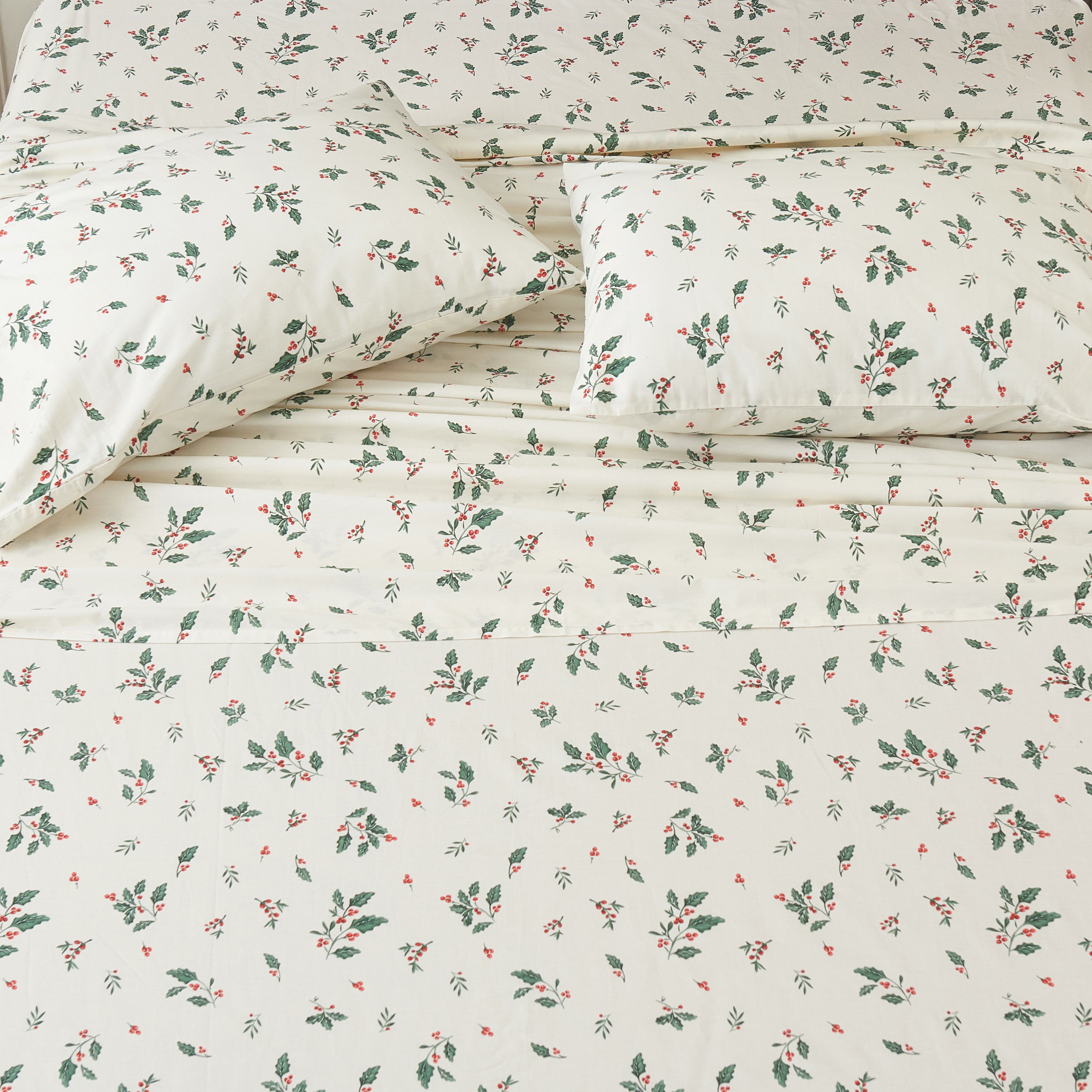 Top-down view of the festive holly berry print cotton sheets bringing joyful holiday cheer to your sleep sanctuary - DAUAOTO