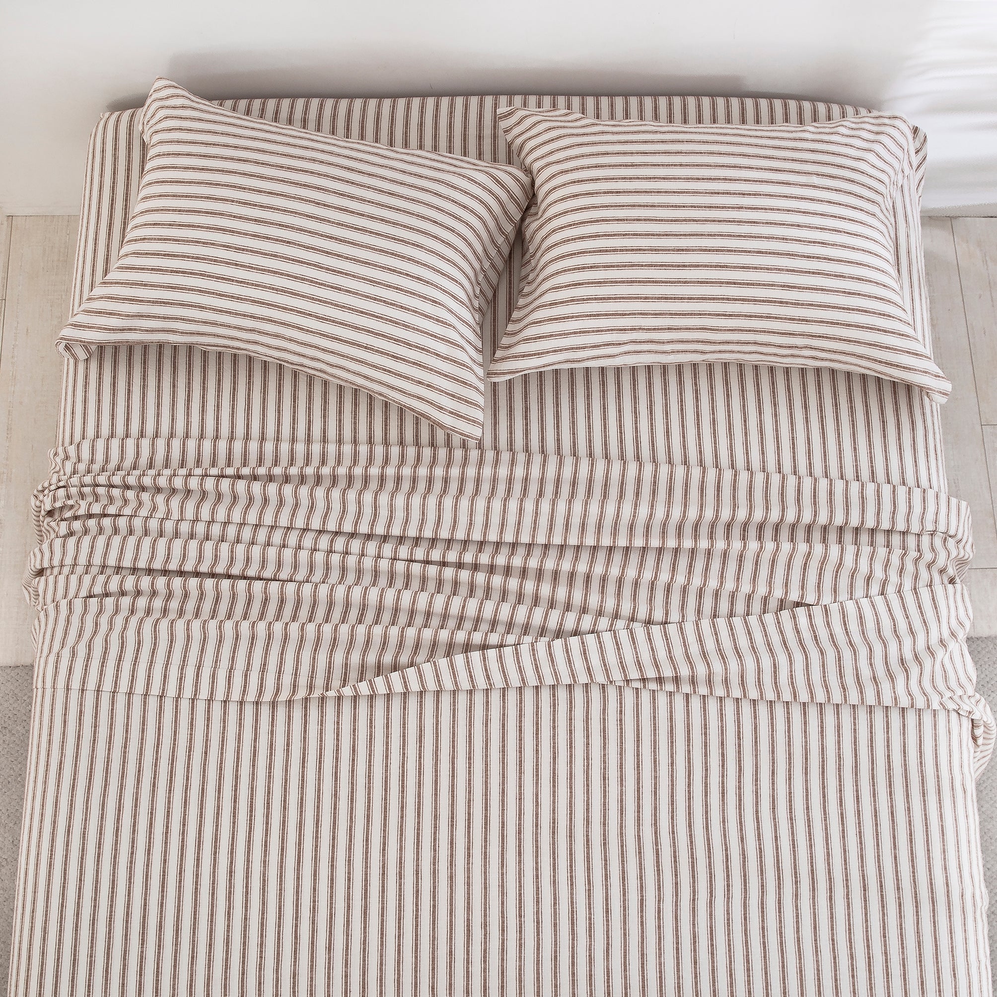 Top-down view of the understated elegance and finely tailored taupe ticking stripe pattern of the linen cotton bed sheets - DAUAOTO