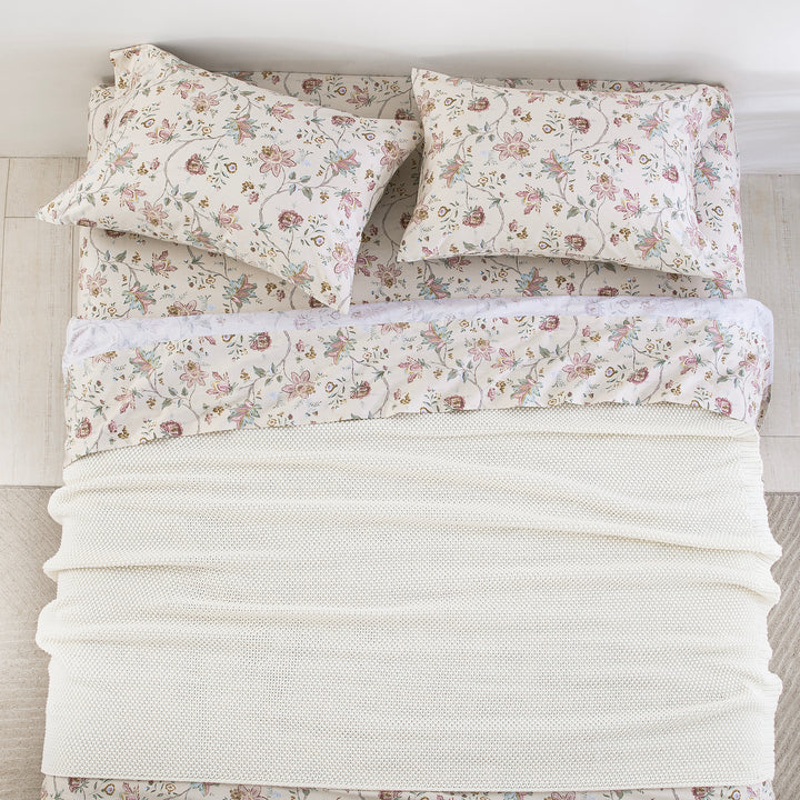 Top-down bird's-eye view of a perfectly made bed featuring the DAUAOTO antique rose floral sheet set layered with a white blanket.