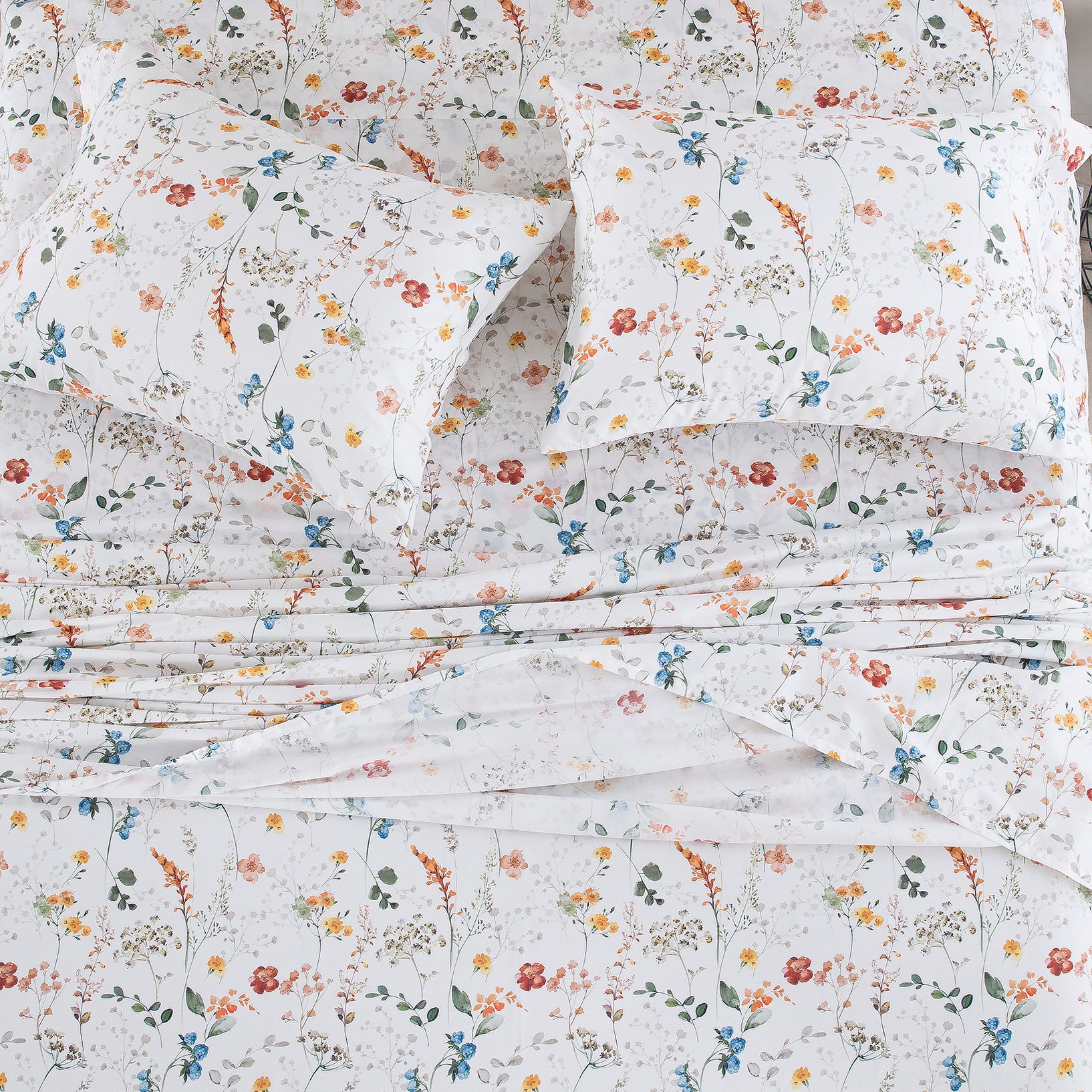Top-down view of the sleep sanctuary styled with the vibrant watercolor wildflower print pure cotton bed sheets - DAUAOTO