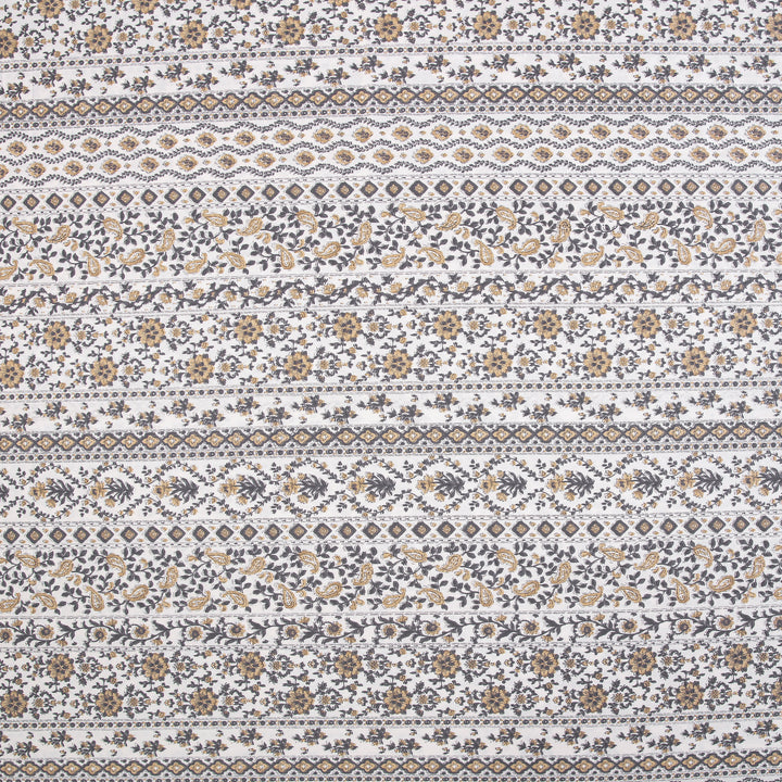 Close-up of DAUAOTO lightweight cotton fabric featuring a traditional block print geometric and floral pattern in mustard yellow and charcoal.