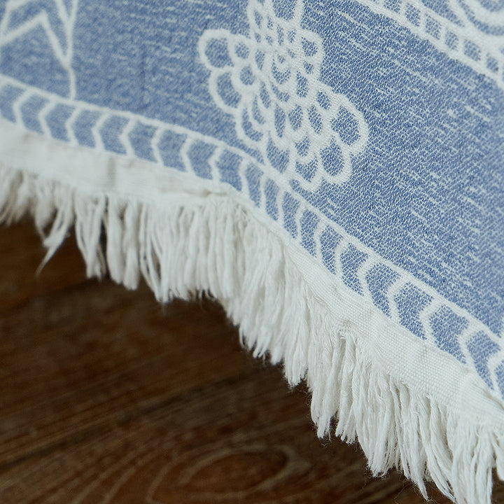 Close-up of the vintage jacquard woven border pattern and delicate fringe on the blue throw.