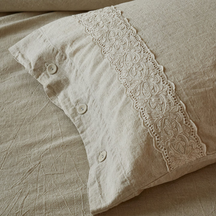 Side view of the oatmeal linen-cotton pillowcase featuring vintage French embroidered lace and natural buttons.