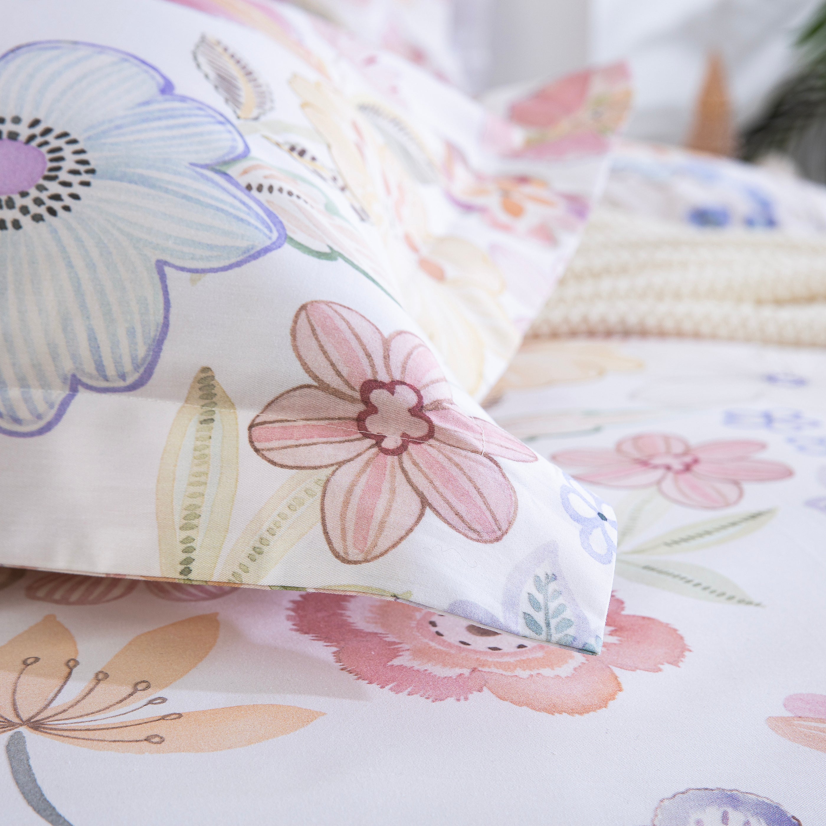 Detail of the DAUAOTO pastel floral 100% cotton pillowcase resting softly on the matching duvet cover.