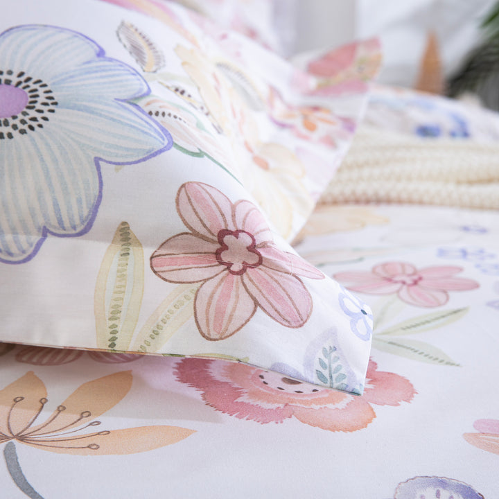 Detail of the DAUAOTO pastel floral 100% cotton pillowcase resting softly on the matching duvet cover.