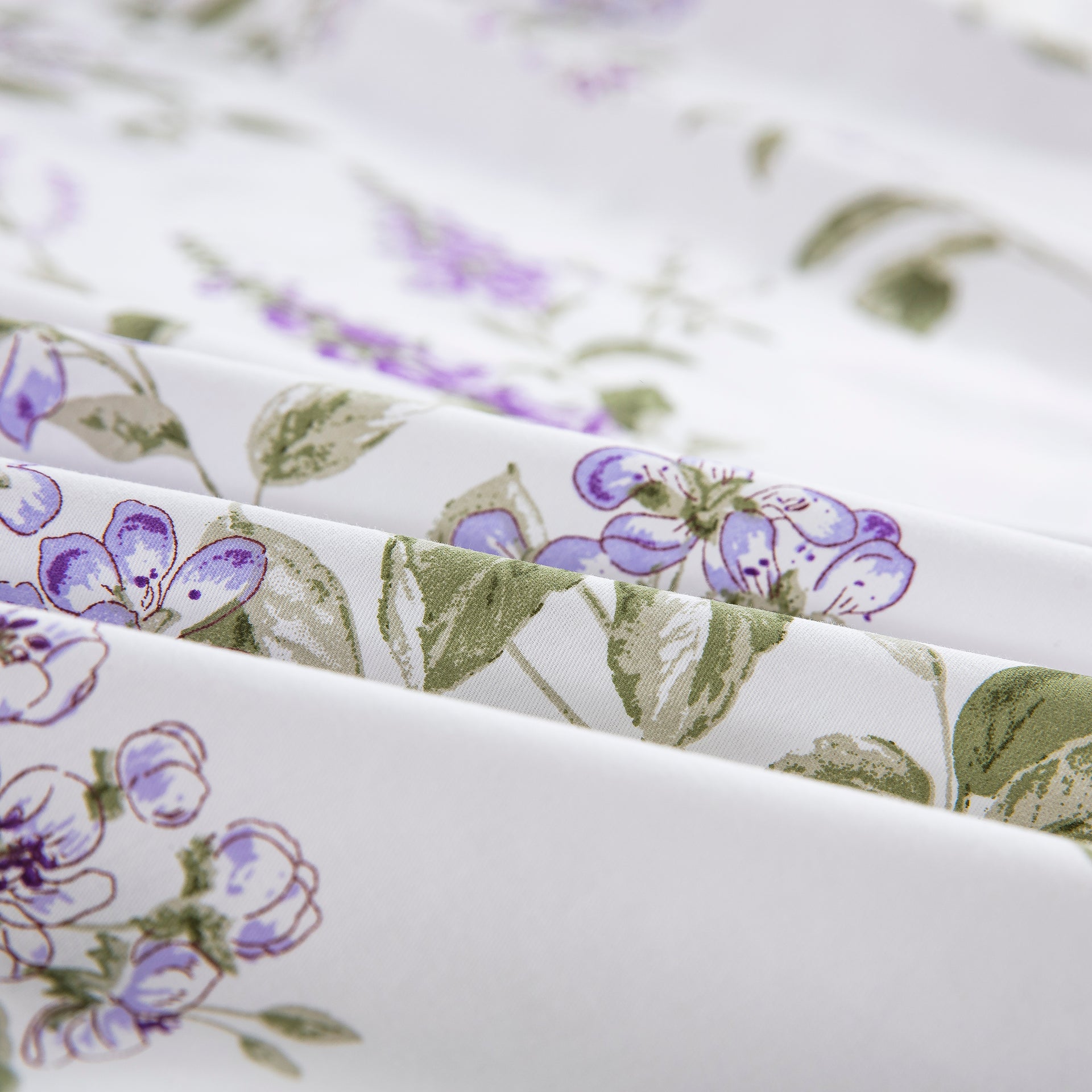 Close-up of the ultra-soft pure cotton fabric showing the delicate watercolor-inspired purple floral pattern on a crisp white ground - DAUAOTO