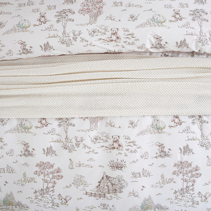 Close-up showing the cozy layered styling of the DAUAOTO vintage woodland cotton duvet cover and knit blanket.